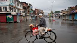 A Kashmiri man rides a bicycle through a deserted street during security lockdown in Srinagar, Indian-controlled Kashmir, on August 14, 2019.