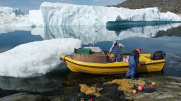 ILULISSAT, GREENLAND - JULY 30: Inuit fishermen prepare a net as free-floating ice floats behind at the mouth of the Ilulissat Icefjord during unseasonably warm weather on July 30, 2019 near Ilulissat, Greenland. The Sahara heat wave that recently sent temperatures to record levels in parts of Europe is arriving in Greenland. Climate change is having a profound effect in Greenland, where over the last several decades summers have become longer and the rate that glaciers and the Greenland ice cap are retreating has accelerated.   (Photo by Sean Gallup/Getty Images)