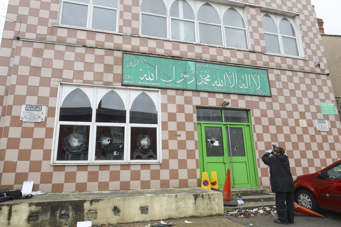 A police forensic officer documents damage to a mosque in Birmingham after several mosques were vandalized in the city in March.