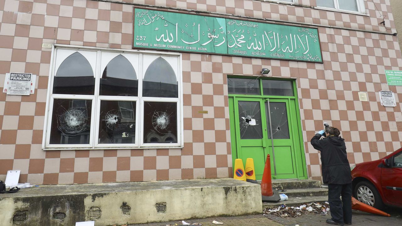 A police forensic officer documents damage to a mosque in Birmingham after several mosques were vandalized in the city in March.