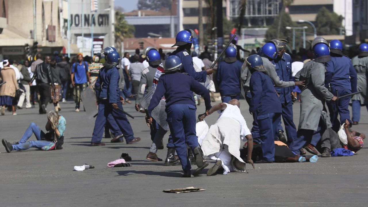 Riot police clash with demonstrators protesting a ban on an opposition rally in Harare on Friday.