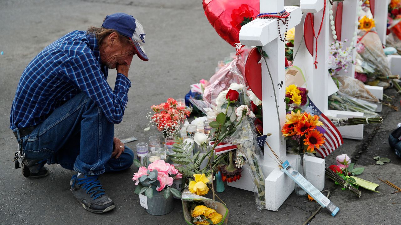 Antonio Basco cries beside a cross at a makeshift memorial near the scene of a mass shooting at a shopping complex, in El Paso, Texas.
