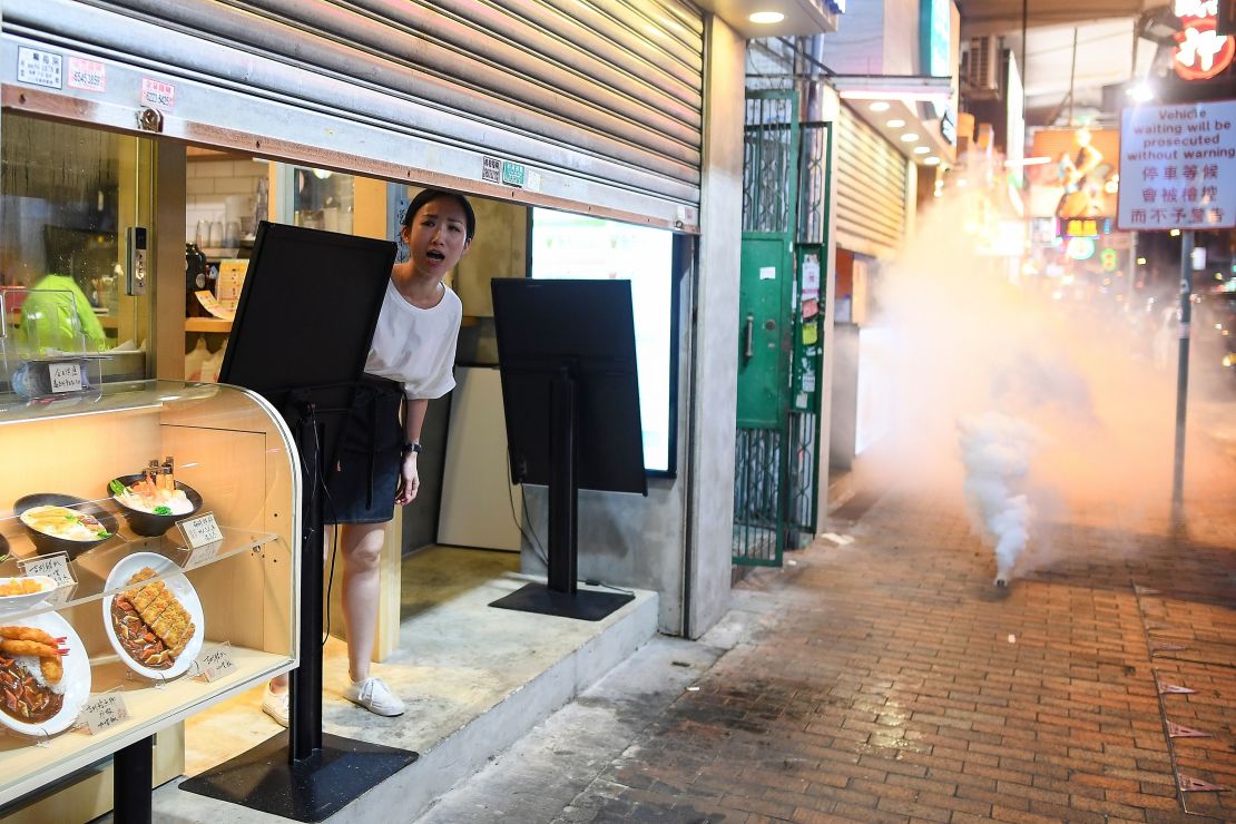 A woman reacts as police personnel fire tear-gas shells to disperse pro-democracy protestors in the Sham Shui Po Area of Hong Kong on August 14, 2019.