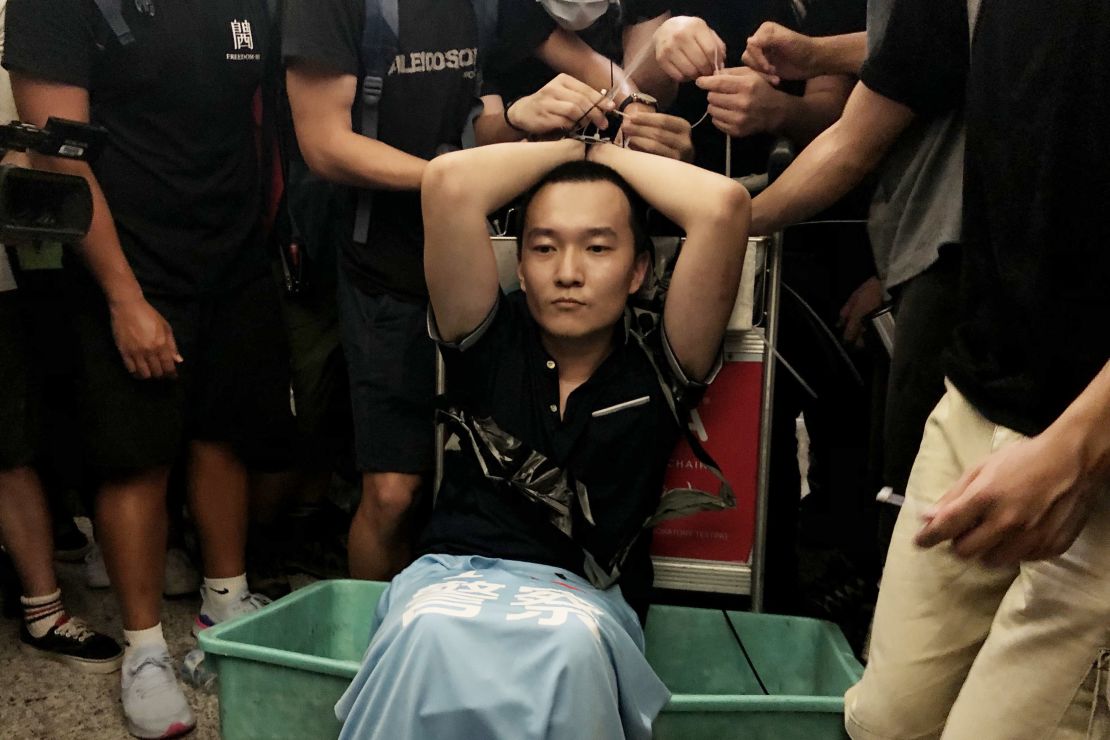Global Times reporter Fu Guohao, who was suspected of being a Chinese spy, is tied up by protesters at the Hong Kong International Airport during a demonstration on August 13, 2019.