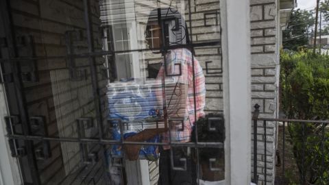 Shakima Thomas carries bottled water into her home.