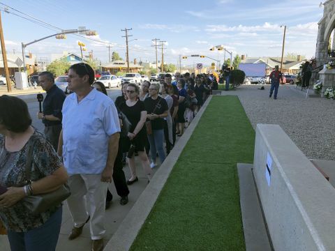 People wait in line in the heat to attend the memorial service for Reckard. 
