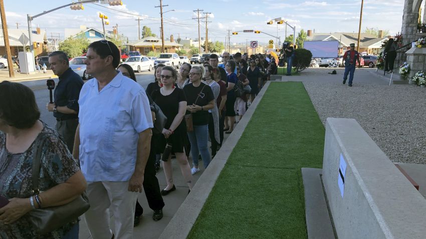 Mourners wait in line, Friday, Aug. 16, 2019, for the memorial services in El Paso, Texas, of Margie Reckard, 63, who was killed by a gunman who opened fire at a Walmart in El Paso earlier in the month. (AP Photo/Russell Contreras)