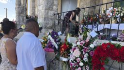 Mourners deliver flowers on Friday, Aug. 16, 2019, for the funeral in El Paso, Texas, of Margie Reckard, 63, who was killed by a gunman in a mass shooting earlier in the month. Hundreds of strangers from El Paso and around the country came to pay their respects Friday after her husband, Antonio Basco, said he felt alone planning her funeral. He invited the world to join him in remembering his companion of 22 years. (AP Photo/Russell Contreras)