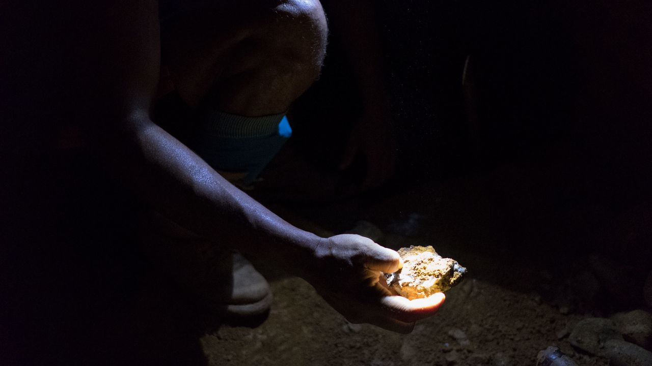 Miner holds a piece of rock, deep inside a mine in Venezuela's Orinoco Mining Arc.
