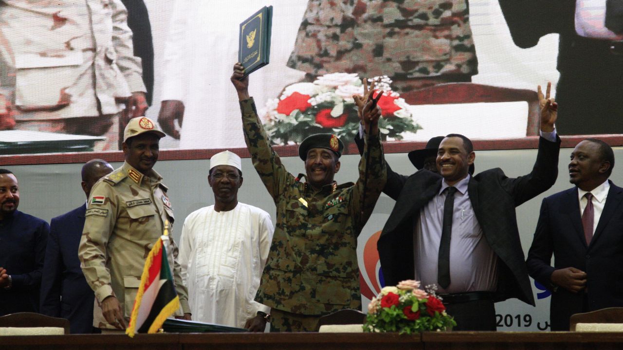 The Transitional Military Council's Gen. Mohamed Hamdan Dagalo, and opposition demonstrator Ahmed Al-Rabee, raise hands after signing the historic agreement.