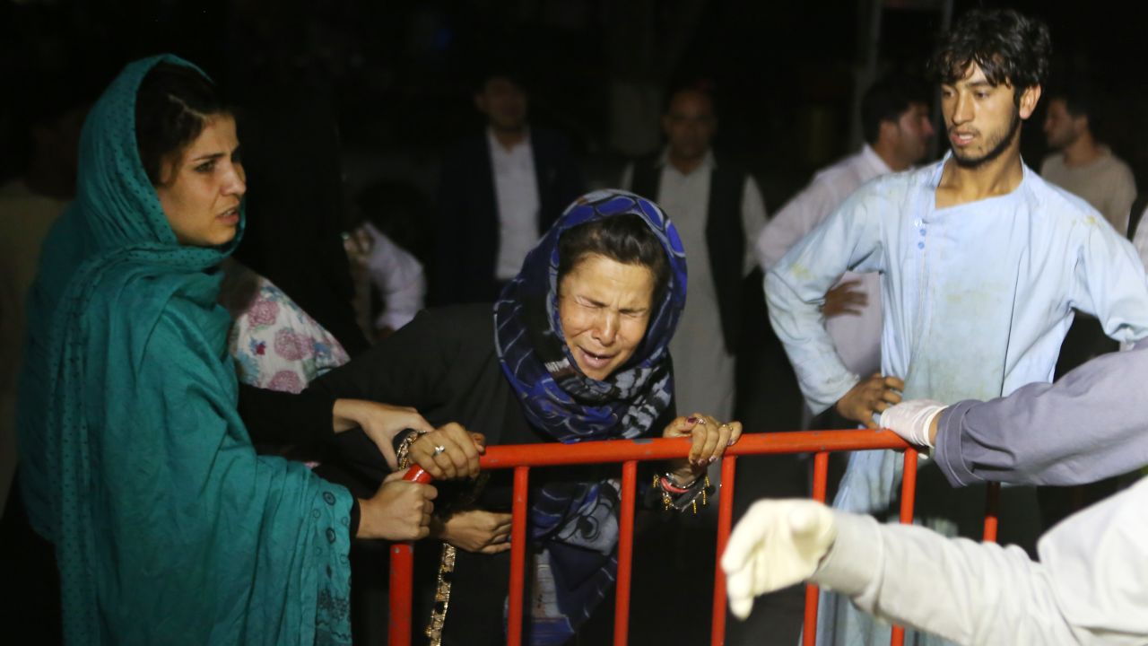 A woman grieves at the door of the hospital, after a blast hit a wedding ceremony in Kabul, Afghanistan.