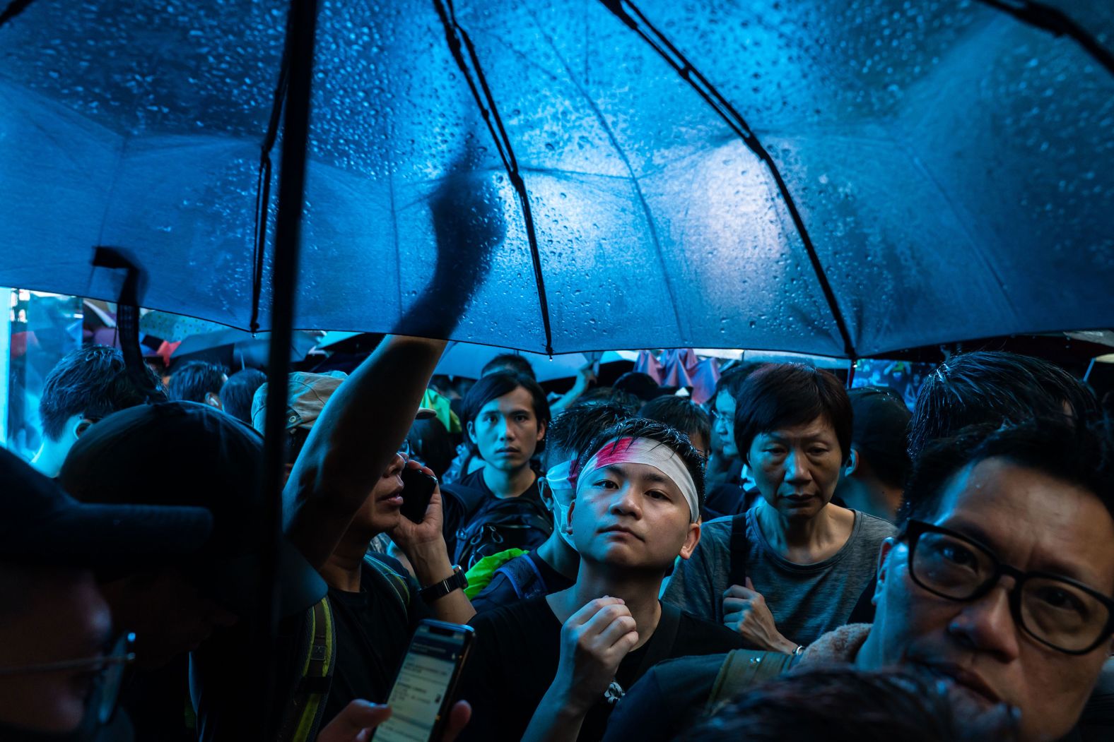 Protesters march under umbrellas on Sunday, August 18.