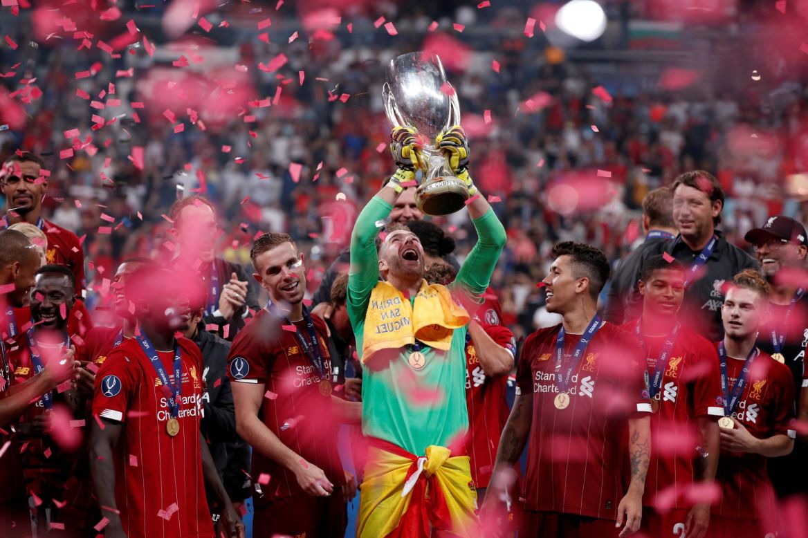 Liverpool's goaltender Adrian lifts the UEFA Super Cup trophy as he celebrates with teammates after defeating Chelsea in the Super Cup final in Istanbul, Turkey, on Wednesday, August 14. Liverpool won in a penalty shootout, where Adrian made the final save to win the match.