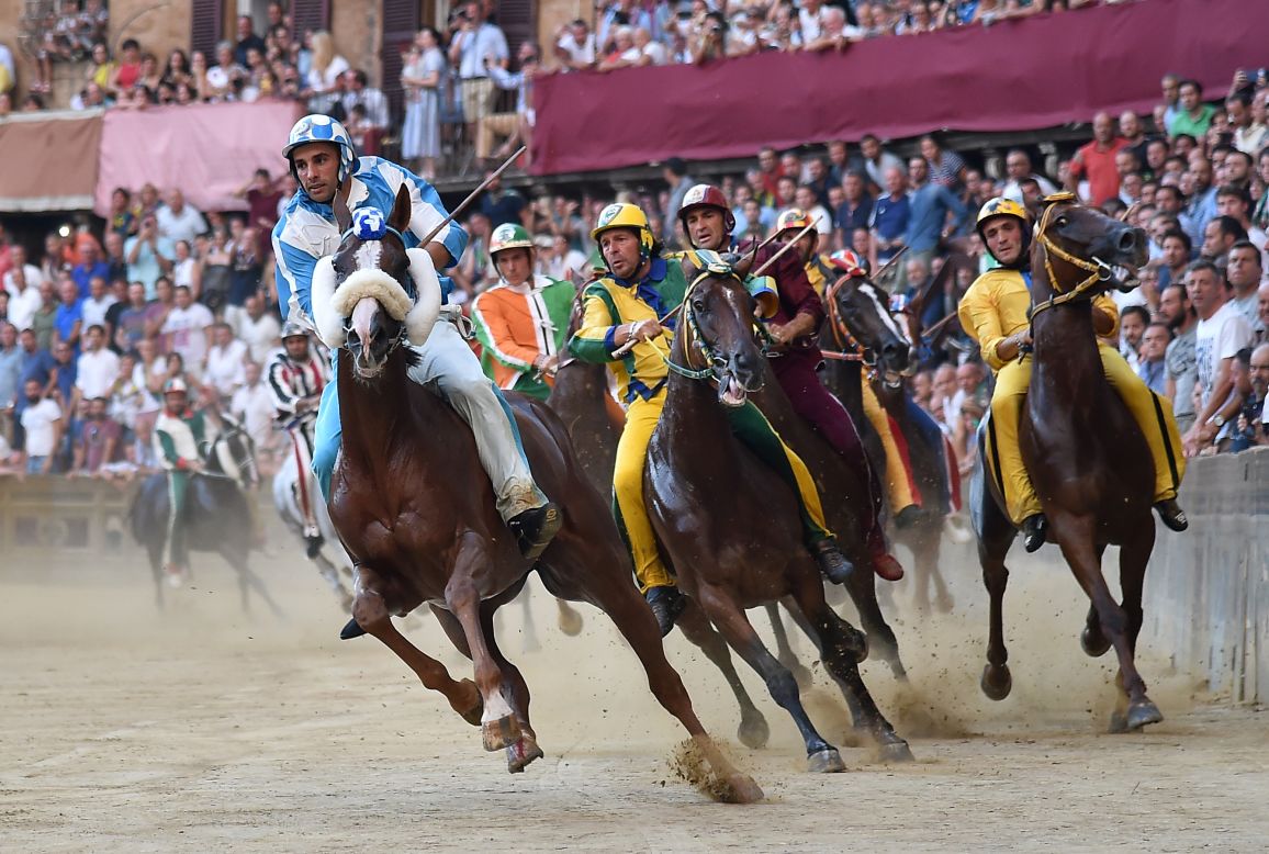 Jockeys ride their horses during the historical Palio of Siena horse race, in Siena, Italy, on August 16.