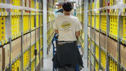 A worker walks in a alley of the Amazon's distribution center of Saran on October 26, 2018, central France. (Photo by GUILLAUME SOUVANT / AFP)        (Photo credit should read GUILLAUME SOUVANT/AFP/Getty Images)