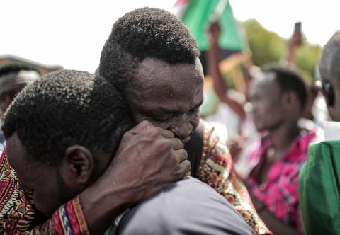 Sudanese men embrace outside the Friendship Hall in Khartoum where generals and protest leaders signed a historic transitional constitution, paving the way for civilian rule in Sudan.