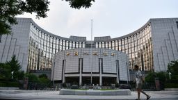 A pedestrian walks past the People's Bank of China (PBOC) headquarters in Beijing, China. 