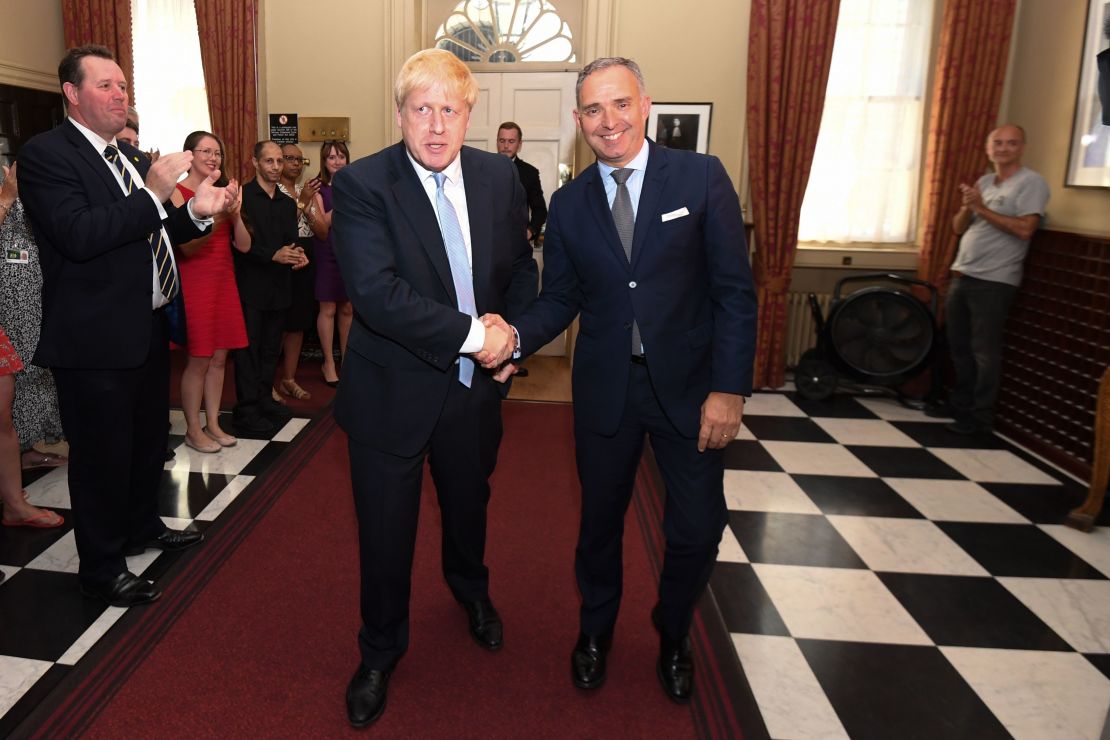 Dominic Cummings is seen in the background (R) on the day Boris Johnson (L) first entered 10 Downing Street as Prime Minister.