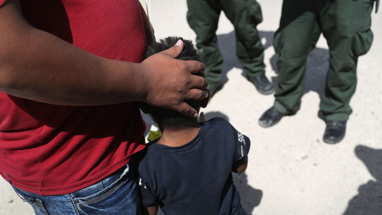 In this June 12, 2018, file photo, US Border Patrol agents take a father and son from Honduras into custody near the U.S.-Mexico border outside Mission, Texas. The asylum seekers were then sent to a US Customs and Border Protection processing center for possible separation. US border authorities were executing the Trump administration's "zero tolerance" policy toward undocumented immigrants. 