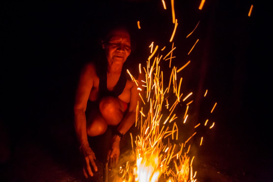 Chief Ajareaty Waiapi builds a bonfire outside her home in Kwapo'ywyry village. 