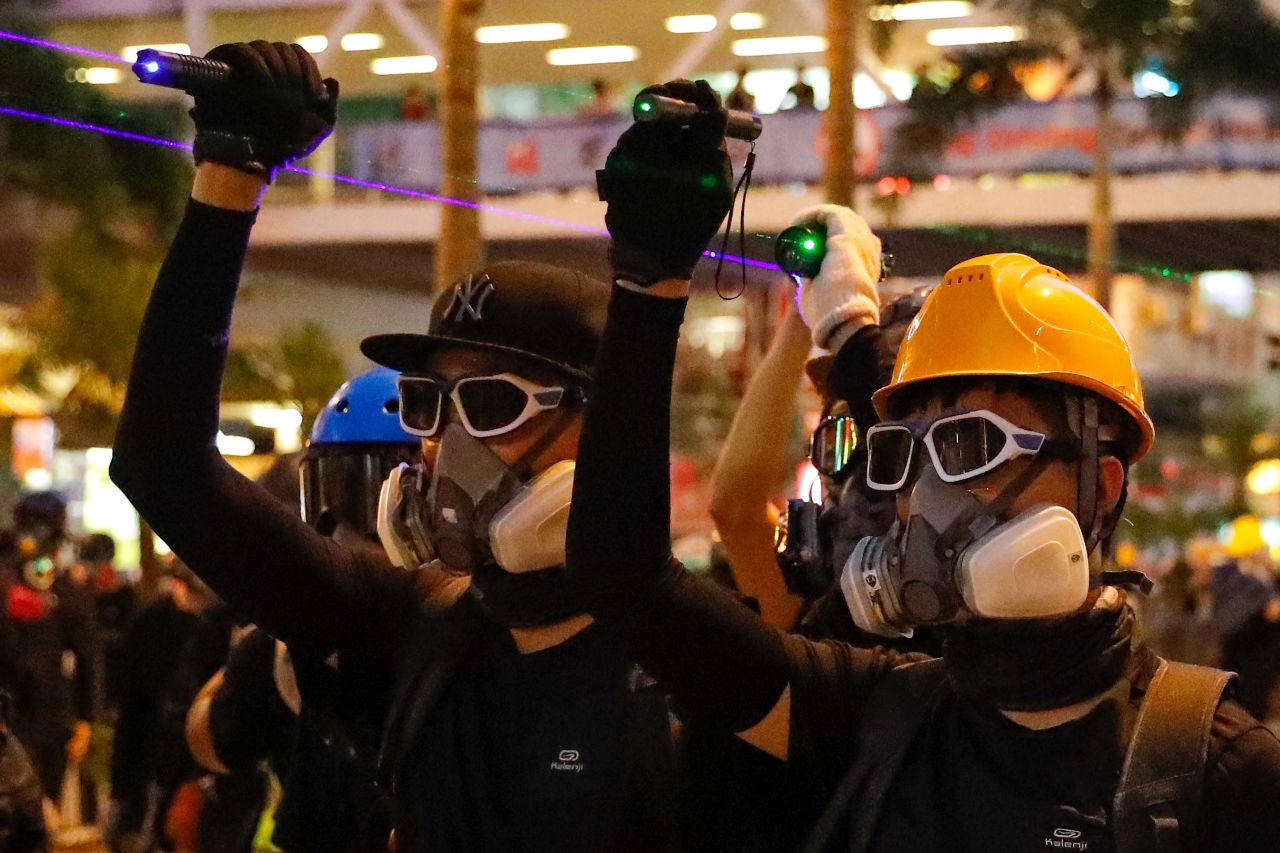 Protesters point laser beams at policemen during a protest in Hong Kong, on August 11, 2019. 