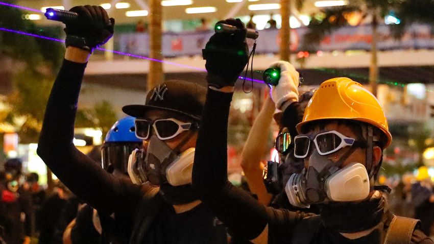Protesters use laser pointers beam at policemen during the anti-extradition bill protest in Hong Kong, Sunday, Aug. 11, 2019. Police fired tear gas late Sunday afternoon to try to disperse a demonstration in Hong Kong as protesters took over streets in two parts of the Asian financial capital, blocking traffic and setting up another night of likely showdowns with riot police. (AP Photo/Vincent Thian)