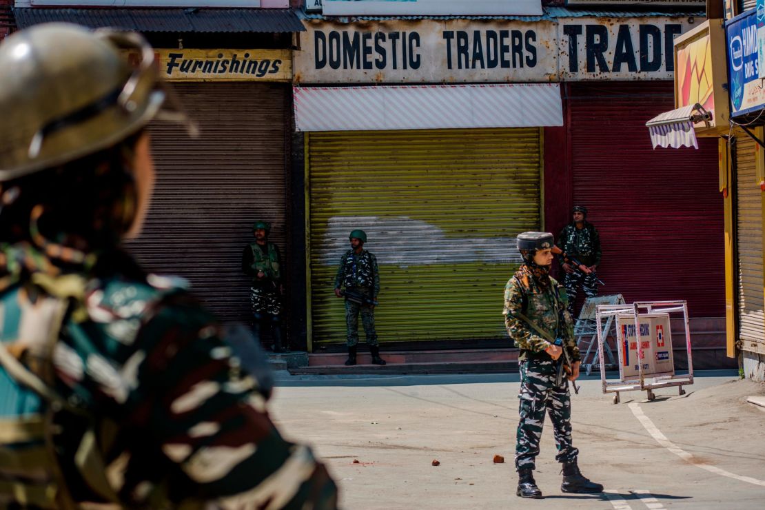  Indian paramilitary troopers stand guard in front the shuttered shops in the deserted city center, on August 20, 2019 in Srinagar.