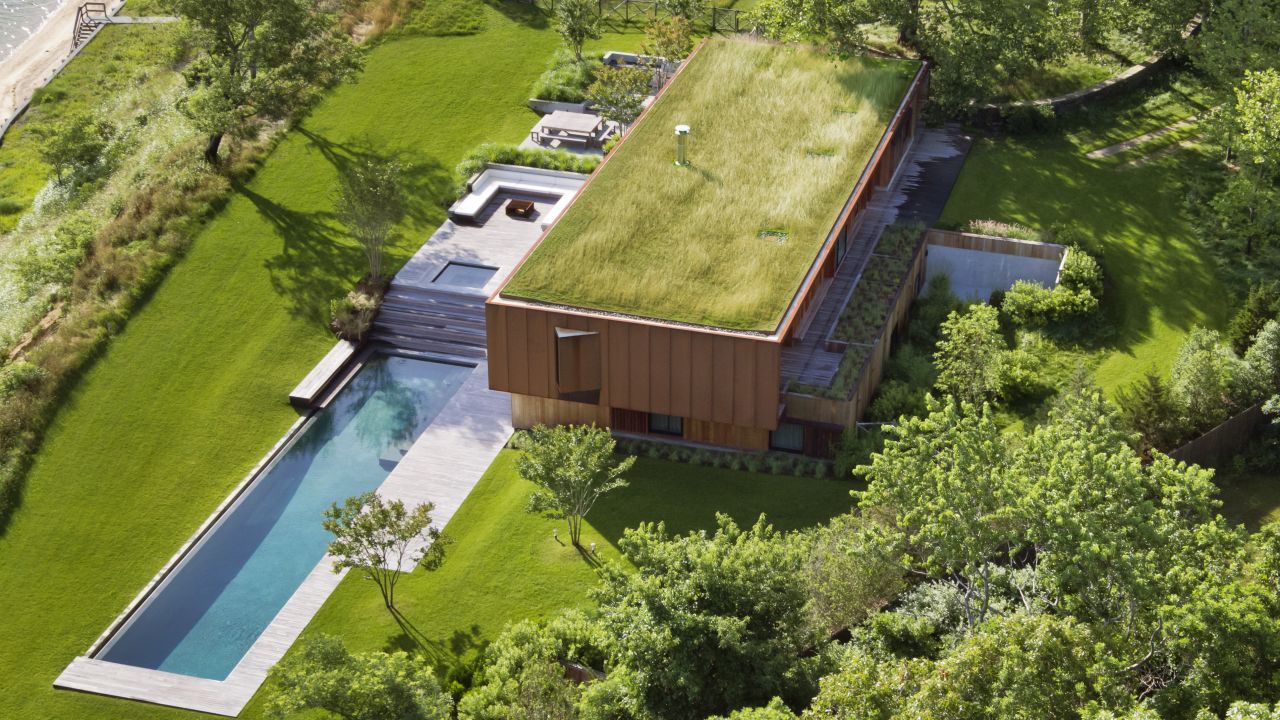The green roof on this home in Hampton Bays gives the illusion that it has been tucked  into the surrounding meadow.