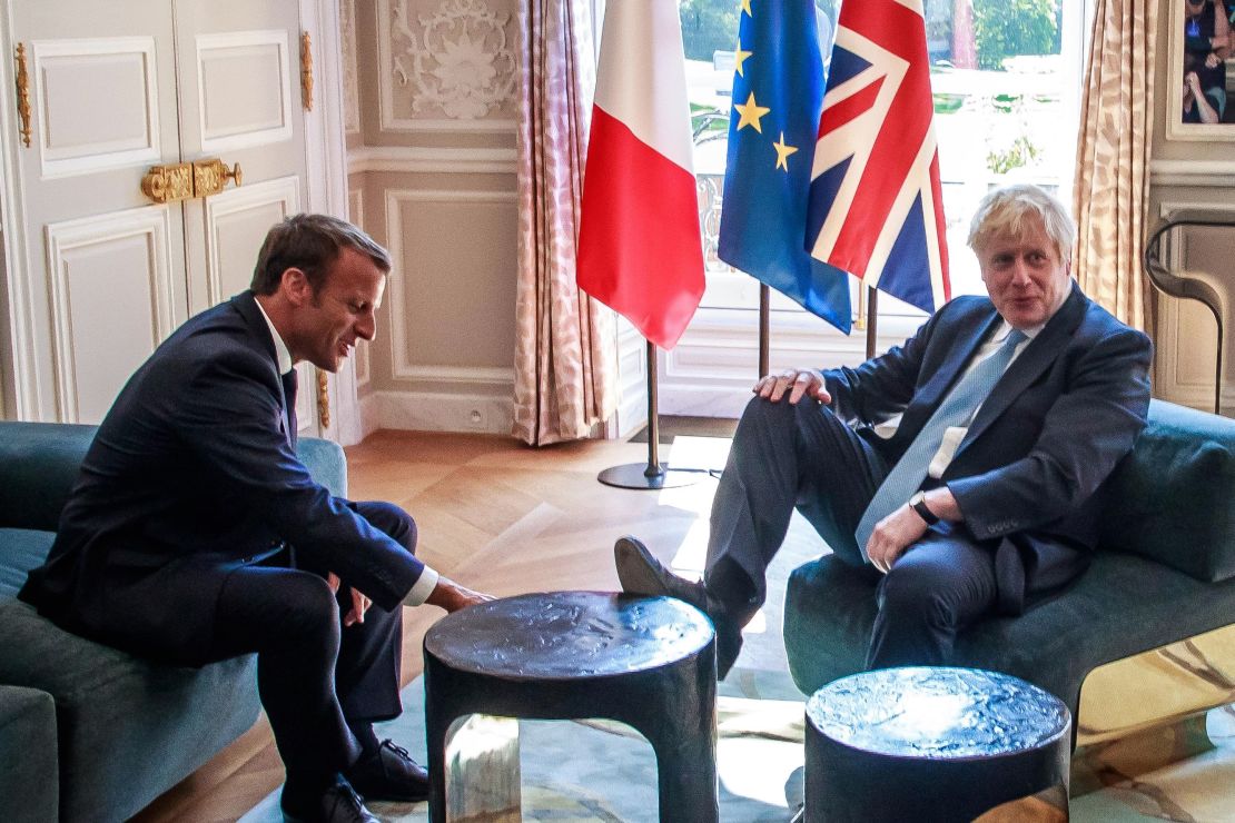 Boris Johnson places his foot on a table during a meeting with French President Emmanuel Macron at the Elysee Palace in Paris on August 22, 2019. 