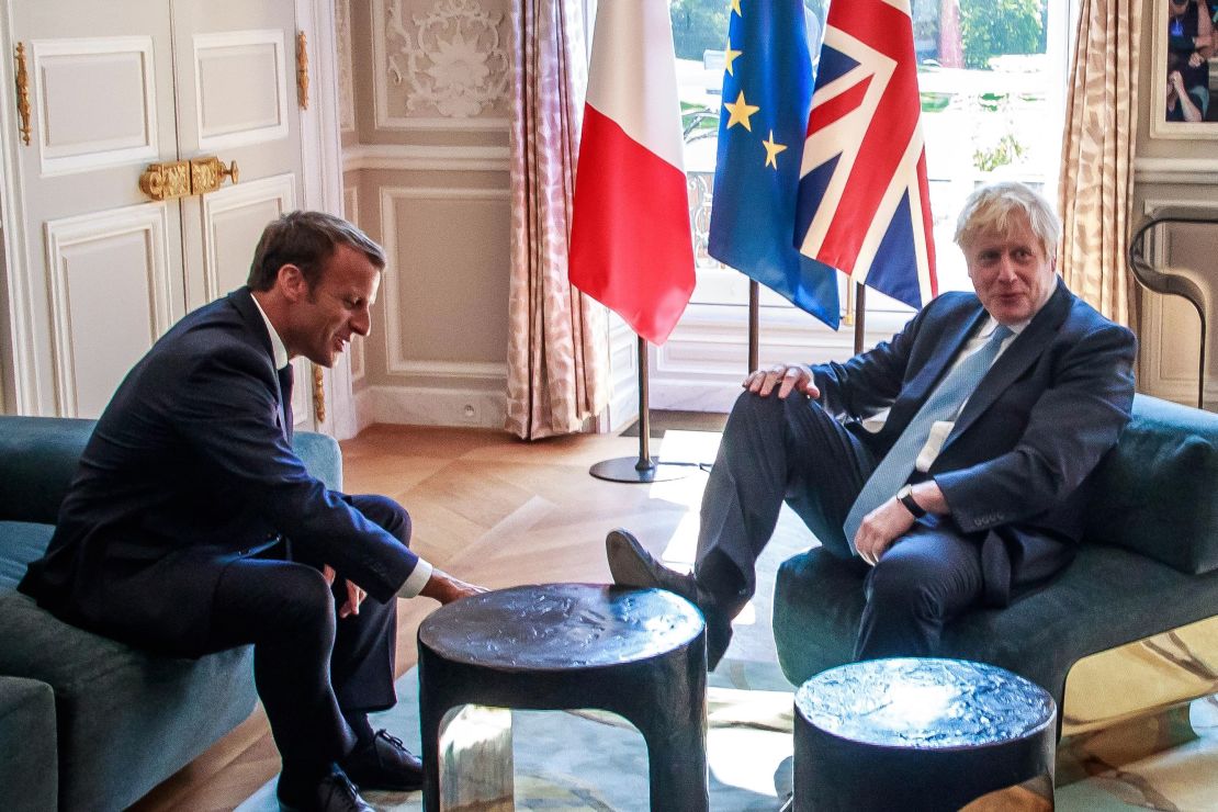 Boris Johnson places his foot on a table during a meeting with French President Emmanuel Macron at the Elysee Palace in Paris on August 22, 2019.