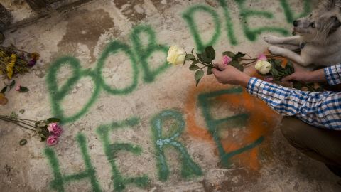 Kyle Haines places flowers on the spot in his home where he believes his husband's body was found.