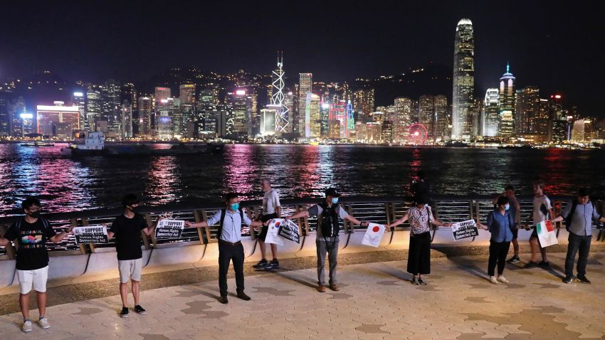 Demonstrators hold signs as they gather at the Tsim Sha Tsui waterfront in Hong Kong, Friday, Aug. 23, 2019. Demonstrators were planning to form a 40 kilometer (25 mile) long human chain Friday night to show their resolve. They said the "Hong Kong Way" was inspired by the "Baltic Way," when people in the Baltic states joined hands 30 years ago in a protest against Soviet control. (AP Photo/Vincent Yu)