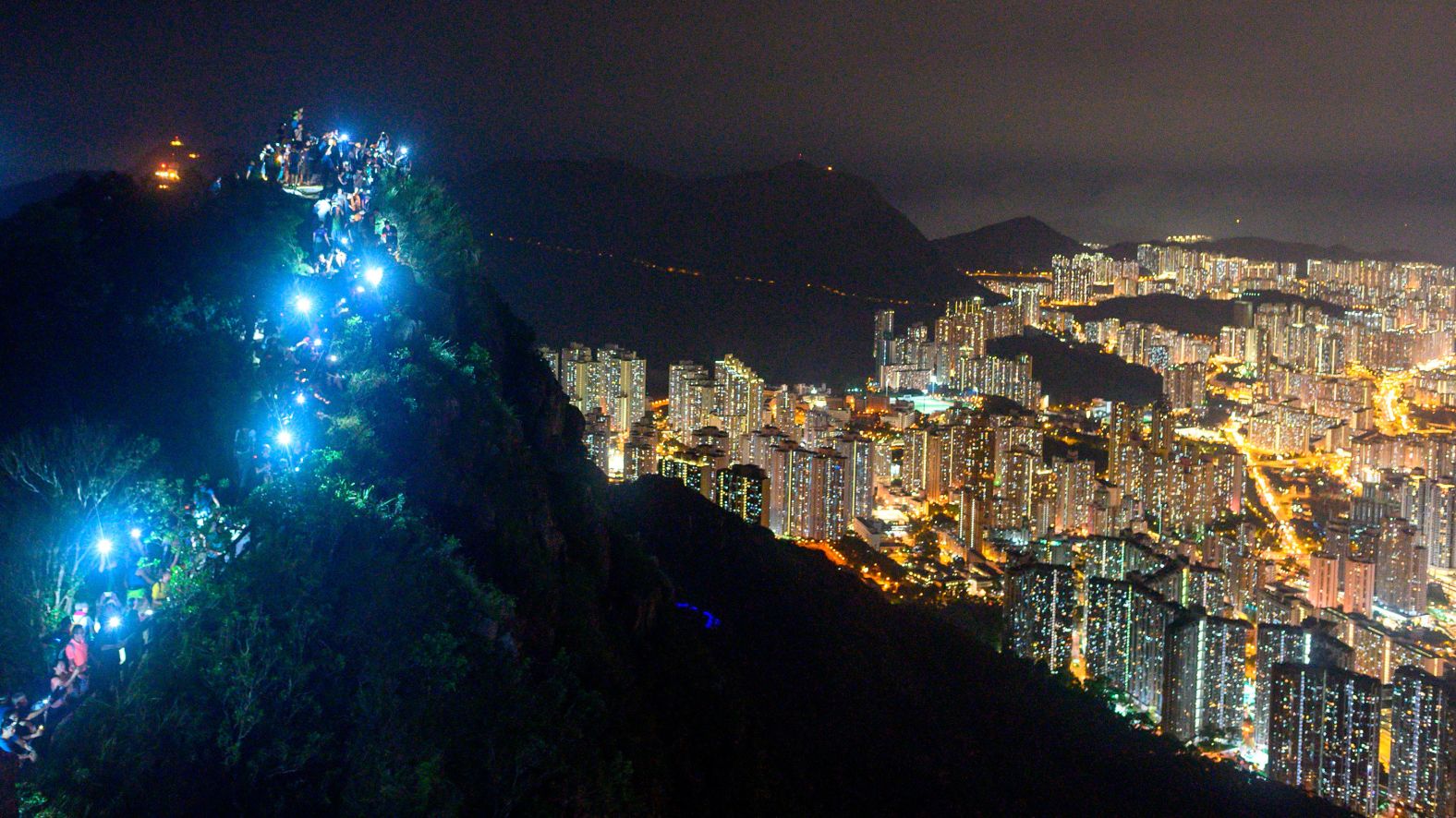 Cell phones shine from the top of Lion Rock on August 23.