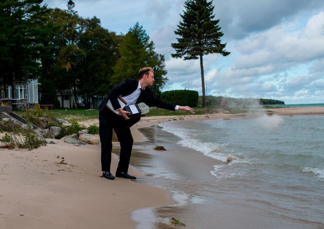Kyle Haines tosses his husband's ashes into the water at a location they frequently visited together in Mackinaw City, Michigan.