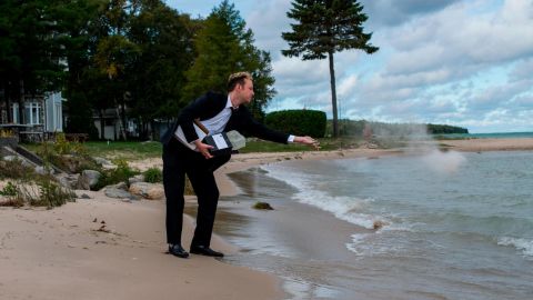 Kyle Haines tosses his husband's ashes into the water at a location they frequently visited together in Mackinaw City, Michigan.