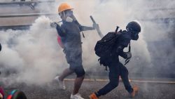 A protester throws back a tear gas canister during clashes with riot police at Kowloon Bay in Hong Kong on August 24, 2019, in the latest opposition to a planned extradition law that has since morphed into a wider call for democratic rights in the semi-autonomous city. - Hong Kong riot police on August 24 fired tear gas and baton-charged protesters who retaliated with a barrage of stones, bottles and bamboo poles, as a standoff in a working-class district descended into violence. (Photo by Lillian SUWANRUMPHA / AFP)        (Photo credit should read LILLIAN SUWANRUMPHA/AFP/Getty Images)