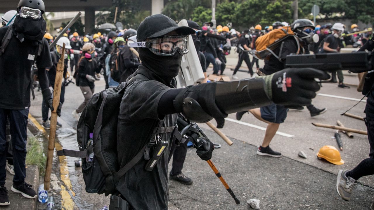 A protester fires a BB gun during clashes with police after a rally in Kwun Tong on Saturday.
