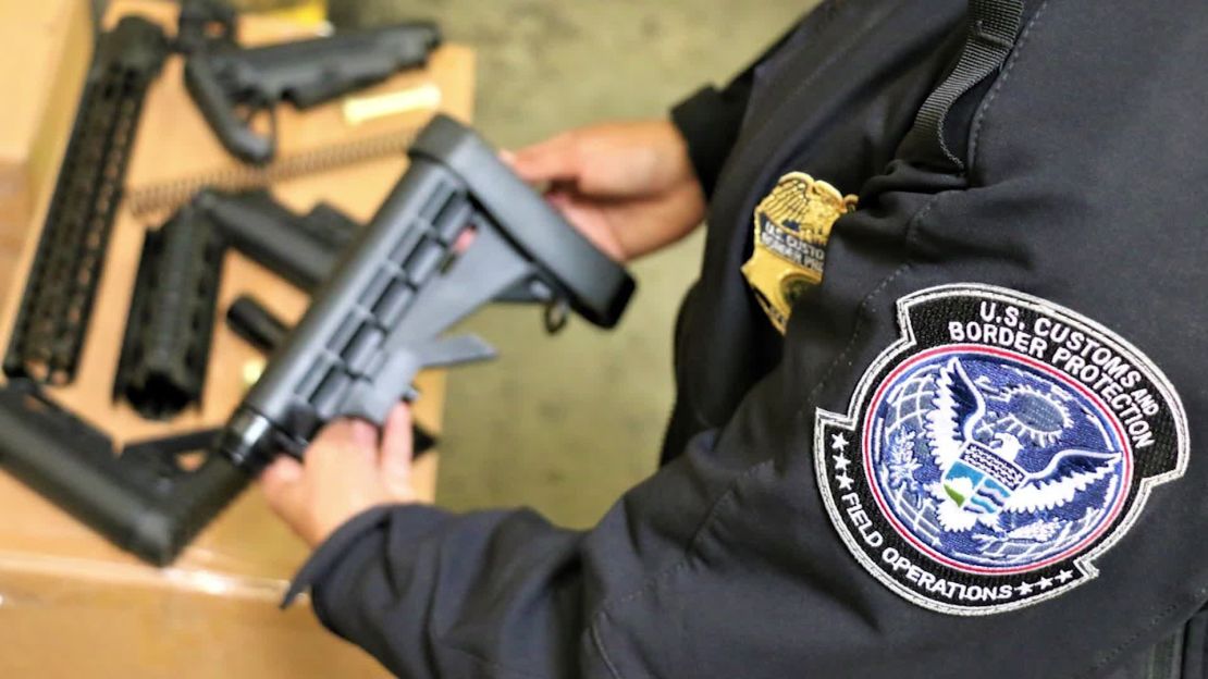 A CBP officer holds one of the seized firearms parts.