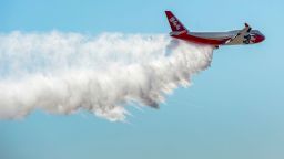 FILE - In this May 5, 2016, file photo, the Boeing 747-400 Global SuperTanker drops half a load of it's 19,400-gallon capacity during a ceremony at the Colorado Springs, Colo., Airport demonstrating the firefighting capabilities of the world's largest firefighting plane. Scott McLean, deputy chief of California's Department of Forestry and Fire Protection said Saturday, July 7, 2018, the supertanker is undergoing final checks at McClellan Air Base outside Sacramento. Once cleared by the state and the U.S. Forest Service, the plane can be sent to fires anywhere in the state. (Christian Murdock/The Gazette via AP, File)