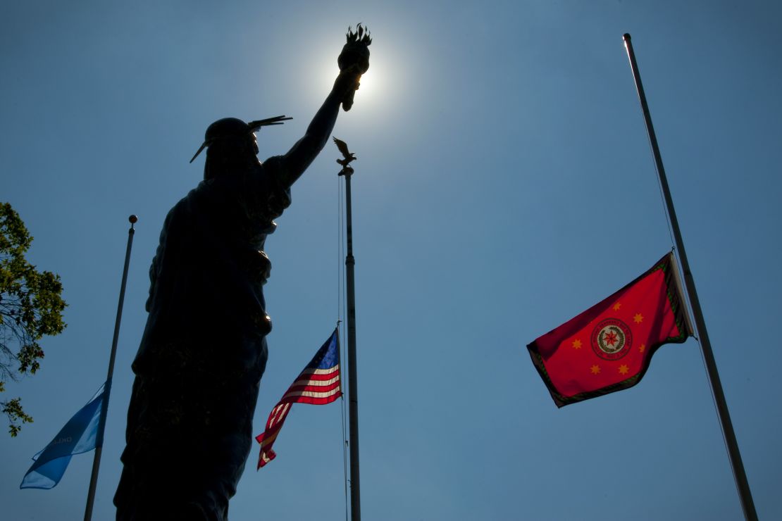 The flags of Oklahoma, the United States and the Cherokee Nation fly behind a sculpture of Lady Liberty at the Cherokee Capitol Square in Tahlequah.