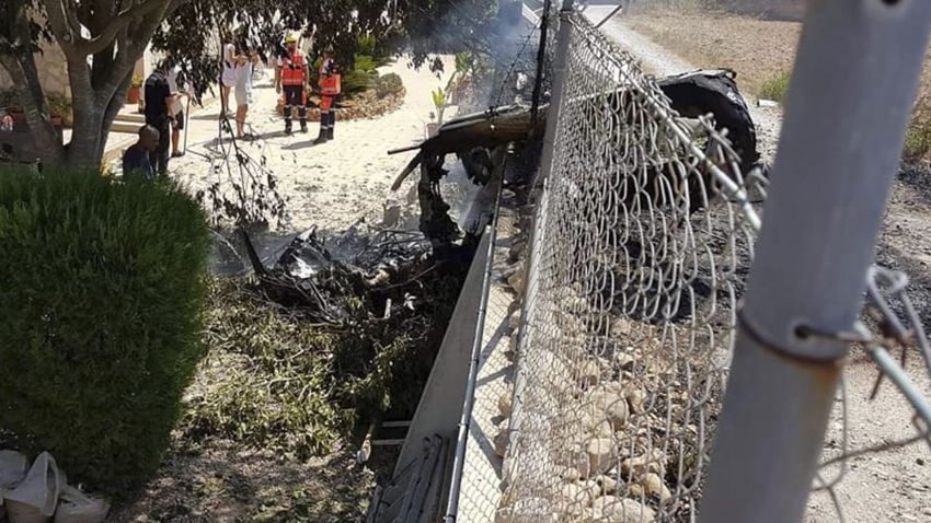 This photo provided by Incendios f.Baleares shows wreckage by a fence near Inca in Palma de Mallorca, Spain, Sunday Aug. 25, 2019. Authorities in Mallorca say at least 5 people have died in a collision between a helicopter and a light plane on the Spanish island. (Incendios f.Baleares Via AP)