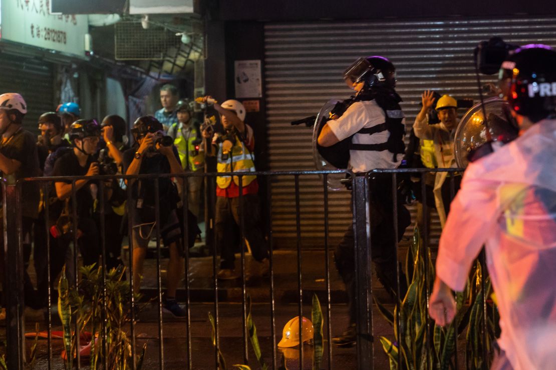 A Hong Kong city police officers points a gun as clashes between pro-democracy protestors and police escalated on Sunday evening.  