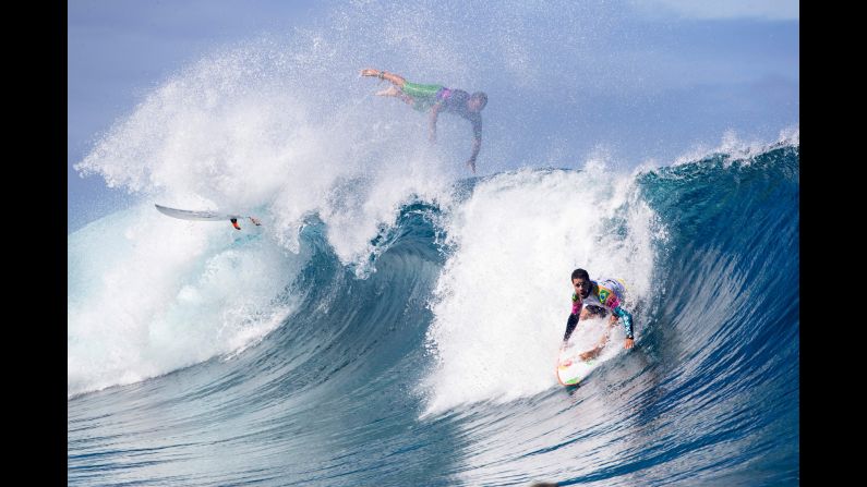 Adriano de Souza, right, catches a wave during the first day of the Tahiti Pro surf contest, while fellow Brazilian surfer Caio Ibelli bails out in Teahupoo, Tahiti, on Saturday, August 24.