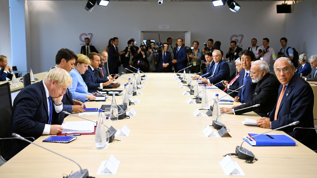 BIARRITZ, FRANCE - AUGUST 26: (L-R clockwise from bottom L) British Prime Minister Boris Johnson, Canadian Prime Minister Justin Trudeau, German Chancellor Angela Merkel, French President Emmanuel Macron, South African President Cyril Ramaphosa, European Council President Donald Tusk, Italian Prime Minister Giuseppe Conte, Japanese Prime Minister Shinzo Abe and Indian Prime Minister Narendra Modi attend a working lunch during G7 summit on August 26, 2019 in Biarritz, France. The French southwestern seaside resort of Biarritz is hosting the 45th G7 summit from August 24 to 26. High on the agenda will be the climate emergency, the US-China trade war, Britain's departure from the EU, and emergency talks on the Amazon wildfire crisis. (Photo by Dylan Martinez - Pool/Getty Images)