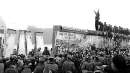 BERLIN - CIRCA NOVEMBER 1989:  People gather near a part of the Berlin Wall that has been broken down after the communist German Democratic Republic's (GDR) decision to open borders between East and West Berlin circa November 1989 in Berlin, West Germany. (Photo by Carol Guzy/The Washington Post/Getty Images)