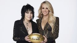 In this photo provided by NBC Sports, Joan Jett, left, and Carrie Underwood pose with a 100th anniversary NFL football. NBC's Sunday Night Football open will return to the original Waiting All Day for Sunday Night song, but this time Carrie Underwood will be joined by Rock & Roll Hall of Fame inductee Joan Jett. Her band, the Blackhearts, also perform in the open, which features NFL stars. (Virginia Sherwood/NBC Sports via AP)