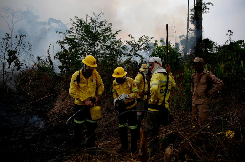 Firefighters rest briefly as they work near Porto Velho, along the road to the Jacunda National Forest.