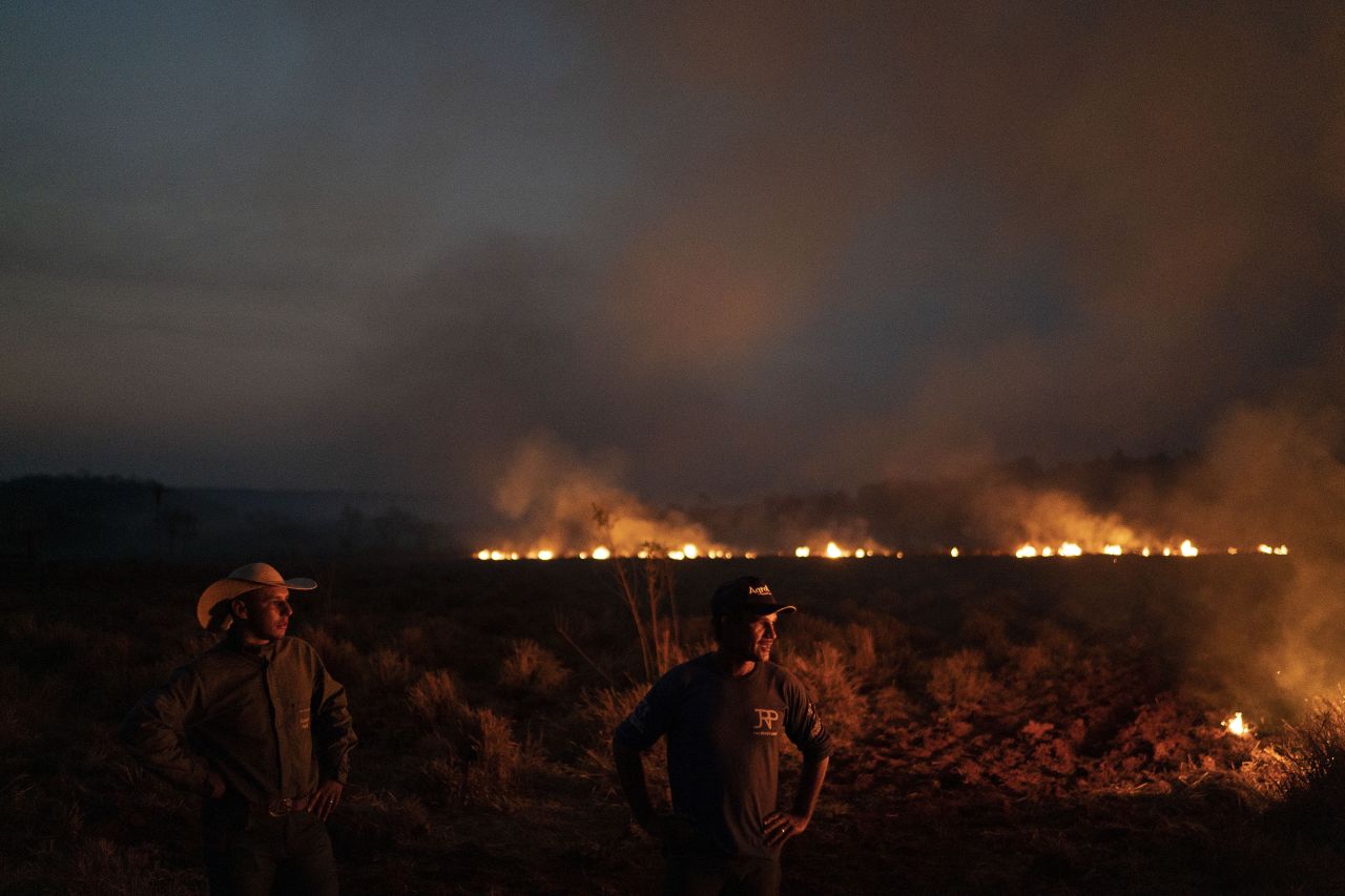 Neri dos Santos Silva, right, watches an encroaching fire in Nova Santa Helena, Brazil, on Friday, August 23. He had just dug trenches to keep the flames from spreading to the farm he works on.