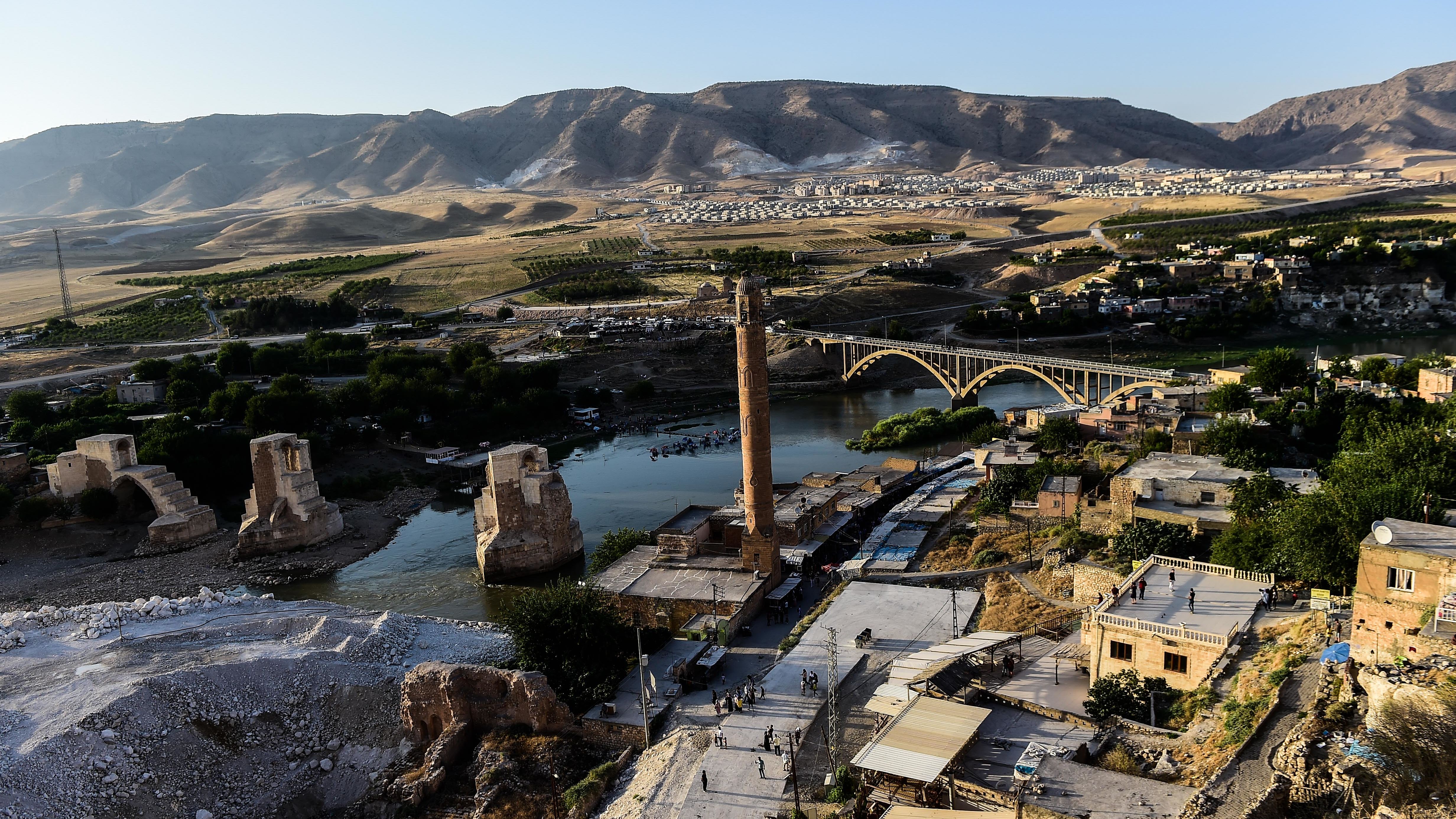 A view of the construction work along the Tigris River that runs through the 12,000-year-old Hasankeyf settlement and ancient citadel town which will soon be significantly submerged by the waters of the nearby Ilisu dam in southeastern Turkey, on July 29, 2018. - The Turkish town of Hasankeyf, a former trading post along the Silk Road, which has seen the Romans, Byzantines, Turkic tribes and Ottomans leave their mark, will soon be partially flooded by the Ilisu Dam, as part of the Southeast Anatolian project (Gap) and one of Turkeys largest hydroelectric projects, which is being built down stream. The inauguration of T