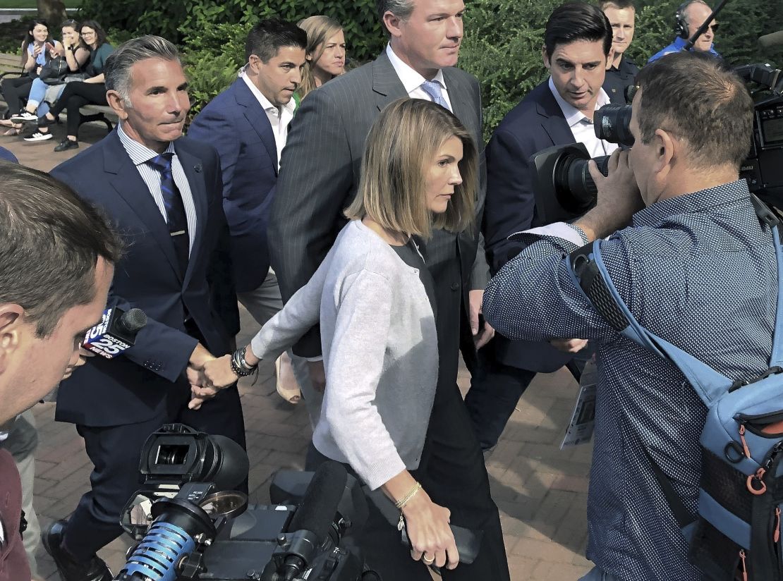 Lori Loughlin and her husband, clothing designer Mossimo Giannulli, leave federal court hand-in-hand on Tuesday in Boston.